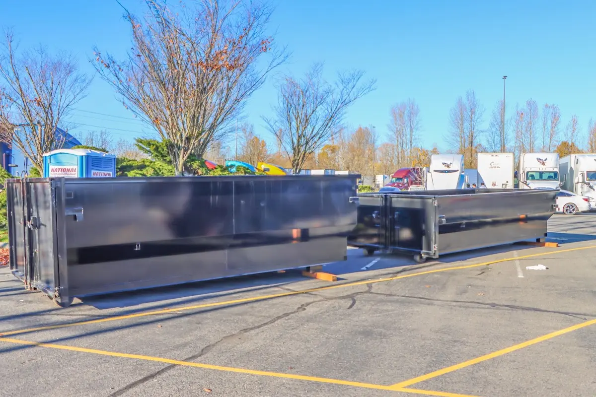 Professional dumpster rental service with roll-off container on residential driveway in Belle Glade